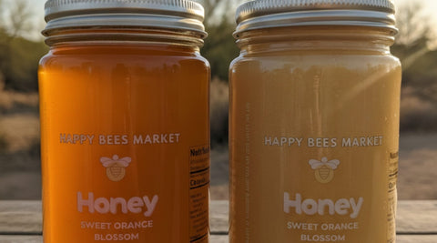 Two jars of Happy Bees Market Orange Blossom Honey, one liquid and one naturally crystallized, on a wooden table in the Sonoran Desert.